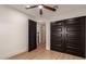Bedroom featuring dark closet doors, modern ceiling fan, wood-look floors, and an open door at 720 E Chilton Dr, Tempe, AZ 85283