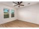 Bright bedroom featuring two windows with neighborhood views, a ceiling fan, and wood-look floors at 720 E Chilton Dr, Tempe, AZ 85283
