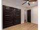Bedroom featuring wood-look floors, modern ceiling fan, and closet with sliding doors at 720 E Chilton Dr, Tempe, AZ 85283
