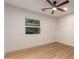 Bright bedroom featuring a modern ceiling fan, wood-look floors, and a window providing natural light at 720 E Chilton Dr, Tempe, AZ 85283