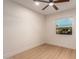 Bright bedroom with a ceiling fan, wood-look floors, and a window offering natural light and neighborhood views at 720 E Chilton Dr, Tempe, AZ 85283