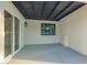 Covered patio area with a black slat roof, smooth concrete surface, and white walls at 720 E Chilton Dr, Tempe, AZ 85283