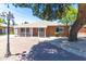 Charming brick home with a welcoming front porch and lovely landscaping with a large tree providing shade at 724 W Missouri Ave, Phoenix, AZ 85013