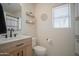 Bathroom featuring a modern vanity, shelving, toilet, and window at 7712 S 64Th Ln, Laveen, AZ 85339