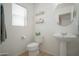 Half bathroom with neutral walls, tile floors, decorative shelving, and a pedestal sink at 7712 S 64Th Ln, Laveen, AZ 85339