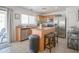 Well-lit kitchen boasts stainless steel appliances, a center island with barstool seating, and sliding door access to the patio at 7712 S 64Th Ln, Laveen, AZ 85339