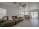 Open concept living room and dining area with tile floors, neutral paint and sliding patio doors at 7712 S 64Th Ln, Laveen, AZ 85339