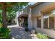 Inviting backyard patio with archway, lush greenery, mature trees, and paver flooring for outdoor enjoyment at 8689 E Krail St, Scottsdale, AZ 85250