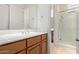 Bathroom with a wooden vanity, spacious mirror, and a glass-enclosed shower at 8689 E Krail St, Scottsdale, AZ 85250
