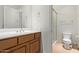 Bathroom with a wood vanity, white countertop, and a glass-enclosed shower at 8689 E Krail St, Scottsdale, AZ 85250