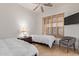 Bedroom with twin beds, neutral decor, shuttered windows, and a ceiling fan at 8689 E Krail St, Scottsdale, AZ 85250
