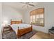 Comfortable bedroom with a ceiling fan, a wooden-framed bed, and shuttered windows at 8689 E Krail St, Scottsdale, AZ 85250