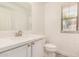 A bathroom featuring a sink, toilet, and window provides natural light to the space at 89 E Palomino Dr, Gilbert, AZ 85296