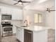 Bright kitchen featuring white cabinetry, stainless steel appliances, an island, and wood-look floors at 89 E Palomino Dr, Gilbert, AZ 85296
