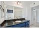 Bathroom with dark granite countertops, framed mirrors, and blue cabinets at 9802 N Balboa Dr, Sun City, AZ 85351
