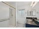 Bathroom featuring a tiled shower, granite countertop, and framed mirrors at 9802 N Balboa Dr, Sun City, AZ 85351