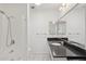Bathroom featuring a tiled shower, granite countertop, and framed mirrors at 9802 N Balboa Dr, Sun City, AZ 85351
