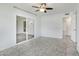 Bedroom featuring tile flooring, a ceiling fan, a sliding glass door, and an open doorway at 9802 N Balboa Dr, Sun City, AZ 85351