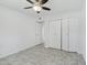 This bedroom boasts tile flooring, a ceiling fan, and closet doors at 9802 N Balboa Dr, Sun City, AZ 85351