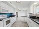 Well-lit kitchen with white cabinetry, black countertops, and modern appliances, perfect for cooking at 9802 N Balboa Dr, Sun City, AZ 85351