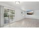 Open living area with tile floors, sliding glass doors, and a mounted television, perfect for modern living at 9802 N Balboa Dr, Sun City, AZ 85351