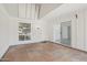 An empty sun room with tile flooring and a white front door and sliding door to the interior at 9802 N Balboa Dr, Sun City, AZ 85351