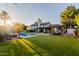 This backyard features a pool, grassy area, covered patio, a poolside cabana and mature landscaping at 9921 E Doubletree Ranch Rd, Scottsdale, AZ 85258