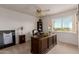Bright home office with a large desk, plantation shutters, and natural light at 9921 E Doubletree Ranch Rd, Scottsdale, AZ 85258