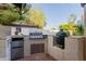 This outdoor kitchen has a built-in grill, mini fridge, Big Green Egg smoker and terra cotta tile flooring at 9921 E Doubletree Ranch Rd, Scottsdale, AZ 85258