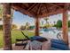 This covered poolside cabana features lounge chairs, a side table, and views of the pool and backyard at 9921 E Doubletree Ranch Rd, Scottsdale, AZ 85258