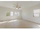 Generously sized bedroom with soft carpeting, a ceiling fan, and multiple windows offering ample natural light at 9939 W Southgate Ave, Tolleson, AZ 85353