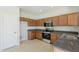 Functional kitchen featuring wood cabinetry, stainless steel appliances, and granite countertops, ideal for cooking enthusiasts at 9939 W Southgate Ave, Tolleson, AZ 85353