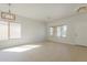 Bright, airy living room with neutral tile flooring, large windows, and modern light fixtures for a welcoming atmosphere at 9939 W Southgate Ave, Tolleson, AZ 85353