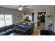 Stylish living room features a sectional sofa, ceiling fan, and seamless flow into the adjacent dining and kitchen areas at 10036 W Chipman Rd, Tolleson, AZ 85353