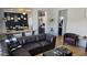 Cozy living room features a plush leather sofa, bar seating in background, and decorative accents at 10036 W Chipman Rd, Tolleson, AZ 85353