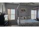 Spacious main bedroom with a four-post bed, decorative walls, and two windows for natural light at 10036 W Chipman Rd, Tolleson, AZ 85353
