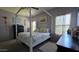 Airy bedroom with a four-post bed, enhanced by natural light from large windows at 10036 W Chipman Rd, Tolleson, AZ 85353