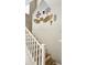 Elegant staircase with white railings leading to upper level, accented with unique wall art at 10036 W Chipman Rd, Tolleson, AZ 85353