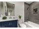 Renovated bathroom featuring a bathtub with elegant gray tile and modern vanity at 10408 W Miami St, Tolleson, AZ 85353