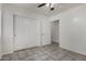 A cozy bedroom with tile floors, ceiling fan and spacious closet at 10408 W Miami St, Tolleson, AZ 85353