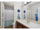 Well-lit bathroom with a large mirror, vanity, and shower with nautical decor at 11253 E Peterson Ave, Mesa, AZ 85212