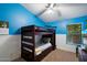 Cozy bedroom with a bunk bed, bright blue walls, and a window at 11253 E Peterson Ave, Mesa, AZ 85212