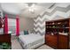 Bedroom featuring a geometric wall design, a dresser, and a comfortable bed at 11253 E Peterson Ave, Mesa, AZ 85212