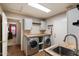 Functional laundry room with a utility sink, washer, dryer and cabinets at 11253 E Peterson Ave, Mesa, AZ 85212
