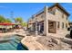 Stunning backyard featuring a sparkling pool, covered patio, fire pit, and lush landscaping at 11965 W Monte Vista Rd, Avondale, AZ 85392