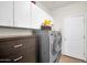 Efficient laundry room equipped with modern washer and dryer, storage cabinets, and tile flooring at 11965 W Monte Vista Rd, Avondale, AZ 85392
