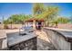 Outdoor kitchen boasts a stainless steel grill, bar, covered seating area with a tv, and ample counter space at 11965 W Monte Vista Rd, Avondale, AZ 85392