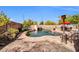 Inviting pool area with rock slide feature, lounge chairs, and privacy landscaping at 11965 W Monte Vista Rd, Avondale, AZ 85392