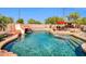 Beautiful backyard oasis with a rock slide pool and an outdoor kitchen and seating area at 11965 W Monte Vista Rd, Avondale, AZ 85392