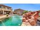 Backyard pool showcases a stunning rock waterfall feature, adding a natural and luxurious element to the outdoor space at 11965 W Monte Vista Rd, Avondale, AZ 85392